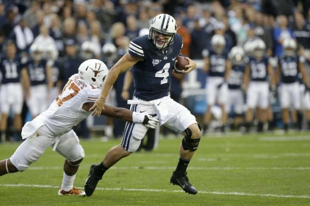 BYU quarterback Taysom Hill, right, and his teammates burned Texas with 550 yards rushing against the Longhorns. UT coach Mack Brown fired defensive coordinator Manny Diaz on Sunday.