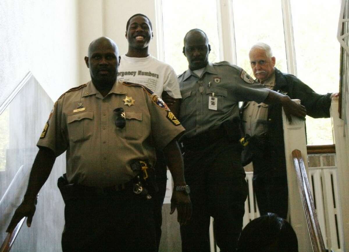 Kelvin “Poppa” King smiles for the camera as he is led away from the Liberty County Courthouse in handcuffs to begin a 15-year sentence for aggravated sexual assault of a child. King is one of 20 males accused of sexually assaulting an 11-year-old Cleveland girl in 2010.