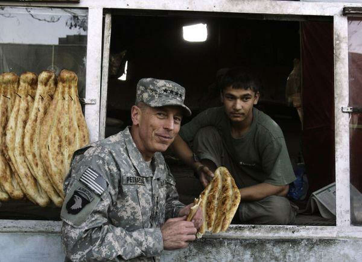 In this July 5, file photo, U.S. Army Gen. David Petraeus, the new commander of U.S. and NATO Forces in Afghanistan, eats bread at a bakery in Kabul, Afghanistan. In comments from Kabul broadcast Aug. 15, Petraeus said progress in Afghanistan only began this spring and needs time to take root.