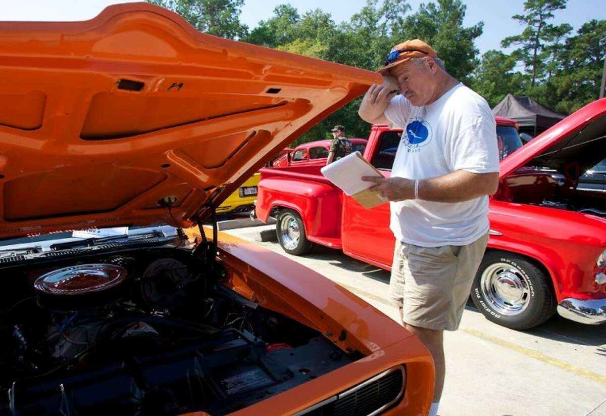 Car judge Walt Worley, of Spring, wipes sweat from his face as he looks over a 1969 Pontiac GTO during Saturday’s Texas Honor Ride event at West Conroe Baptist Church. The event benefited wounded warriors and their families at the Brooke Army Medical Center in San Antonio.