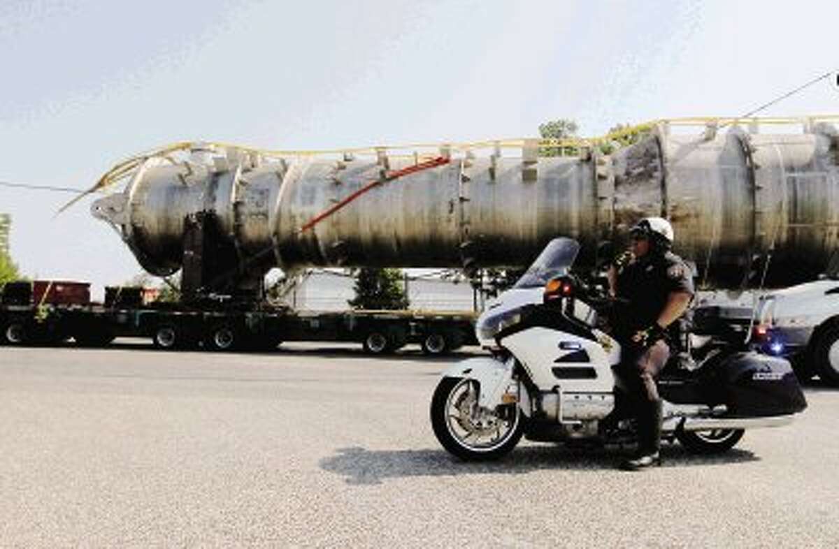 A Sheriff’s Department officer looks on as a convoy carrying refinery equipment is transported along FM 3083 on its way from the Port of Houston to Kansas Friday.