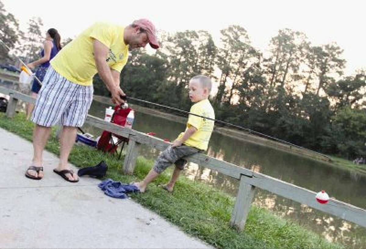 Matthew Wilison shows his son Vincent how to cast during The Woodlands Kiwanis Club’s annual Kids’ Fishing Classic at Creekwood Park Saturday. Go to HCNPics.com to view and purchase this photo and others like it.