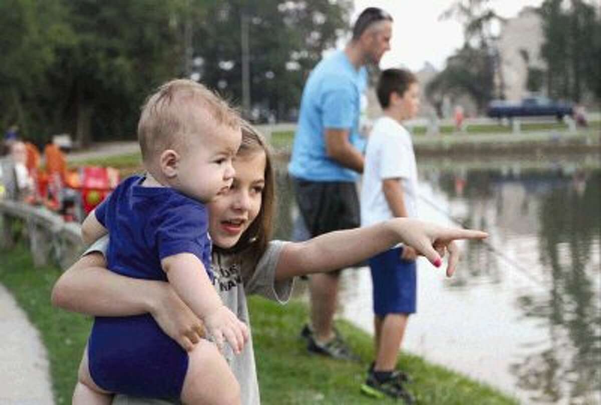 Cami Johnson points out ducks to her little brother Patrick during The Woodlands Kiwanis Club’s annual Kids’ Fishing Classic at Creekwood Park Saturday. Go to HCNPics.com to view and purchase this photo and others like it.