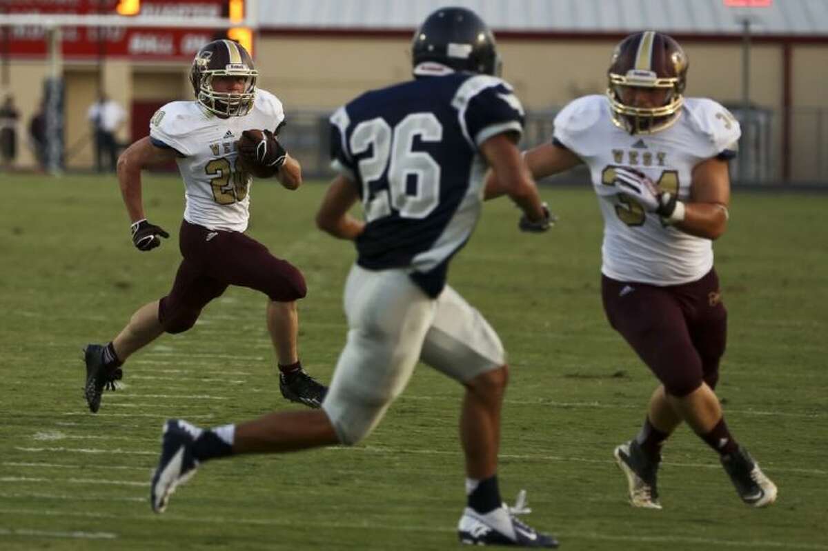 Magnolia West's Chris Nicholson, left, follows his blocks in the Mustangs’ 34-15 victory over Tomball Memorial.