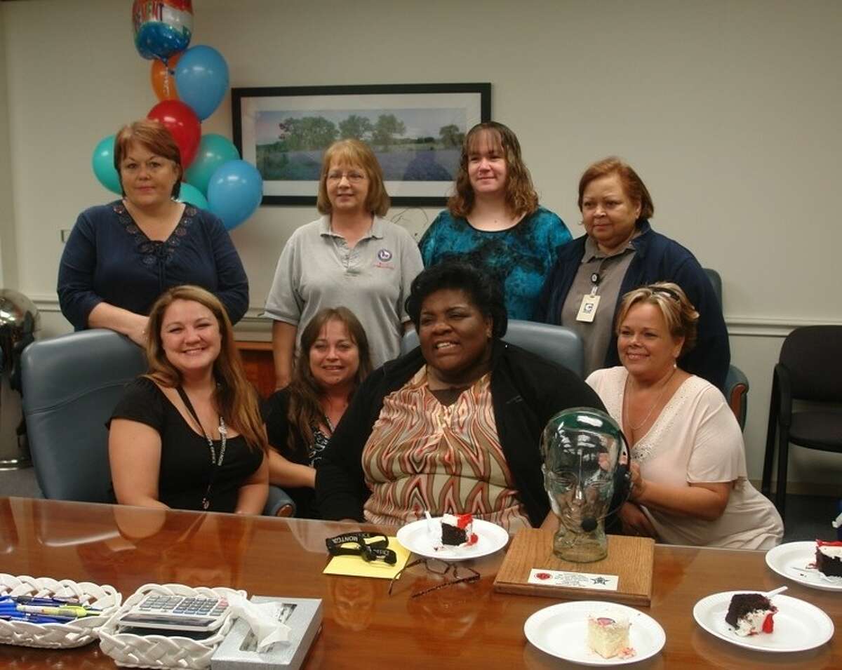 Dorothy Brown-Willis (center, seated) retired from her position as a 911 call taker with the Montgomery County Emergency Communication District Thursday afternoon. Surrounded by co-workers and other deputies, Brown-Willis gave a tearful but lighthearted goodbye to her workplace of 25 years and was honored with a glass fixture in the shape of a 911 call taker’s head and plaque.