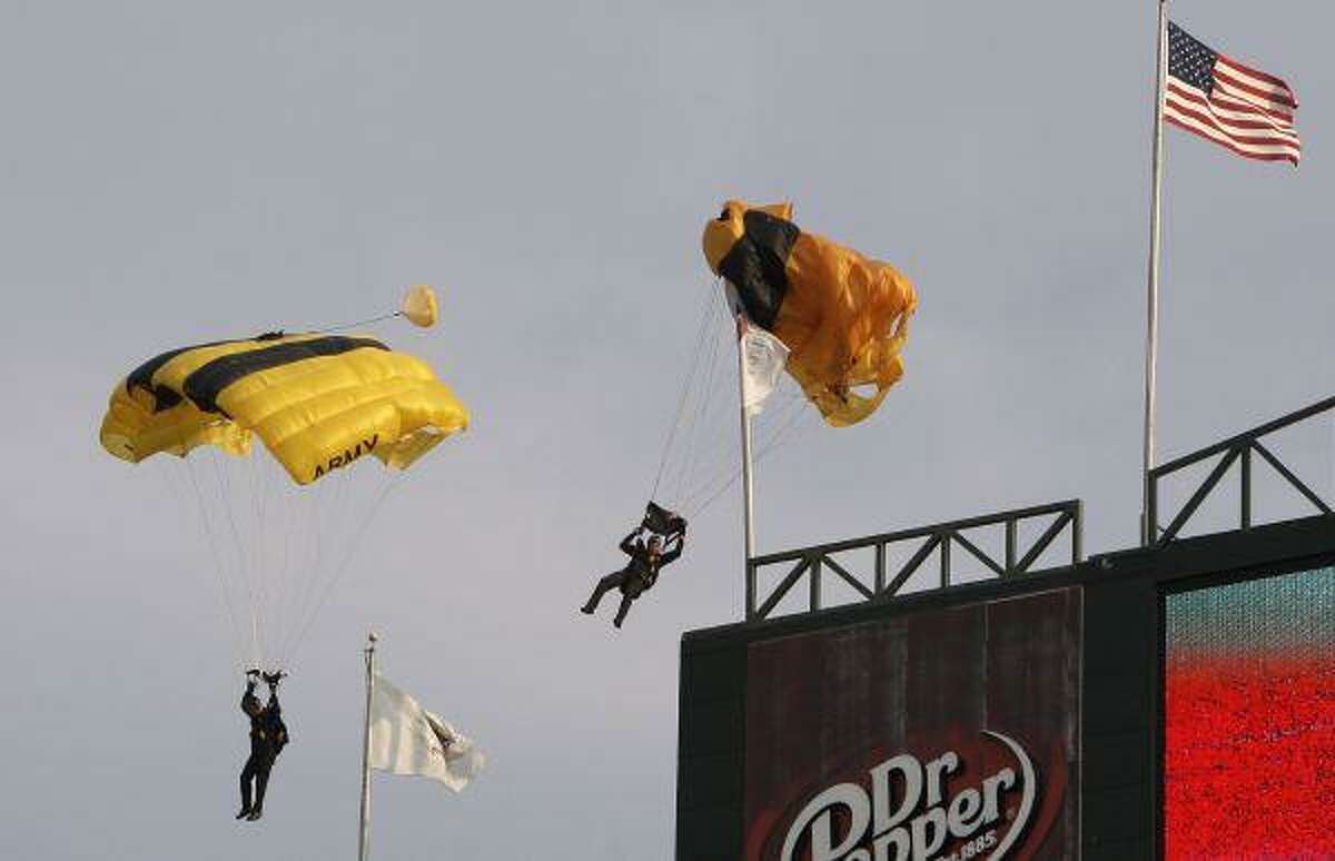 A member of the U.S. Army Golden Knights parachute team gets hung up on a flagpole during a jump into the ballpark before the baseball game between the Minnesota Twins and the Texas Rangers in Arlington Tuesday. No one was reported injured in the minor mishap.