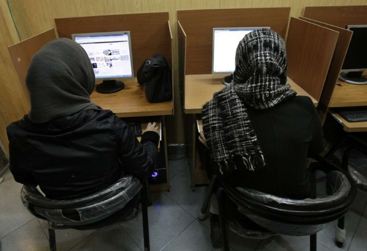 In this Feb. 13, 2012 file photo, Iranian women use computers at an Internet cafe in central Tehran. Iran’s cyber monitors often tout their efforts to fight the West’s 'soft war' of influence through the web, but trying to ban Google’s popular Gmail may have gone too far with complaints coming even from email-starved parliament members.