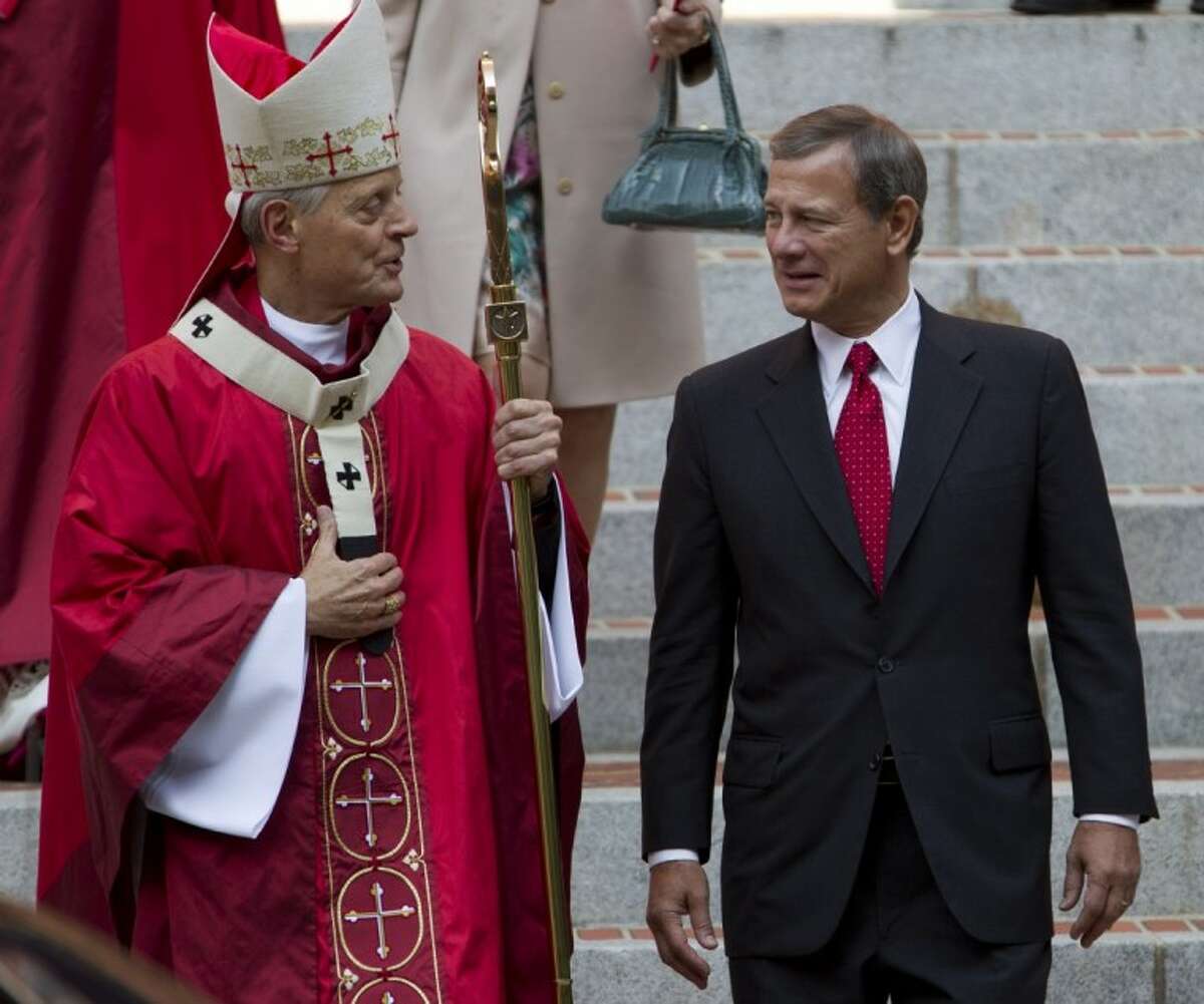 Cardinal Archbishop of Washington Donald Wuerl speaks with U.S. Supreme Court Chief Justice John G. Roberts on the steps of the Cathedral of St. Matthew the Apostle after the 60th annual Red Mass in Washington on Sunday. The Red Mass is held traditionally in Washington the day before the Supreme Court’s new term opens.