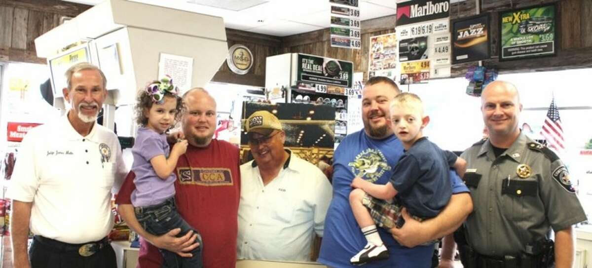 Montgomery County Precinct 4 Justice of the Peace James Metts, left, and Constable Kenneth “Rowdy” Hayden, right, are pictured with members of the Overall family (second from left to right: Ricky Overall, a photo of the late Floyd Overall on cardboard and Jason Overall) at the family’s story, Overall Grocery in New Caney. The family has joined the elected officials’ “Do Your Part” program to battle illegal drug use in East Montgomery County.