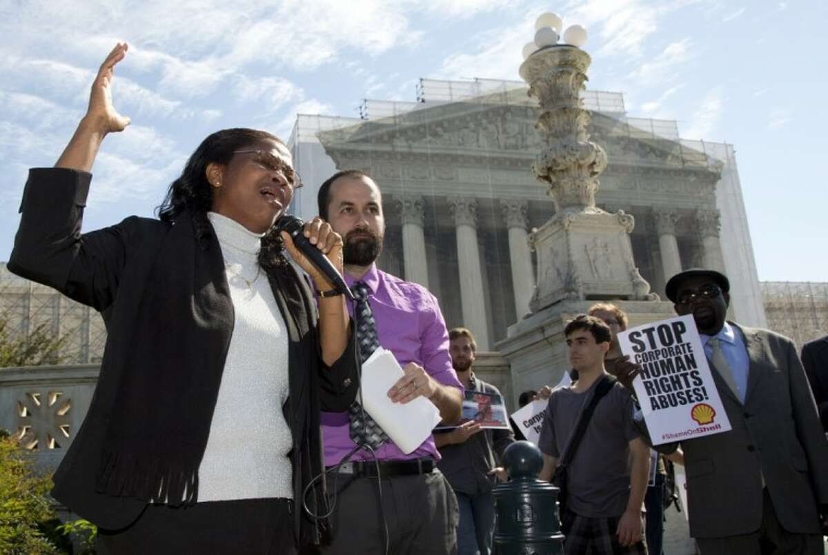 Nigerian widow Esther Kiobel, a plaintiff in Kiobel v. Royal Dutch Petroleum, cries as she speaks outside the Supreme Court in Washington, Monday. Standing with her second from left is Brad Weikel with EarthRights International.