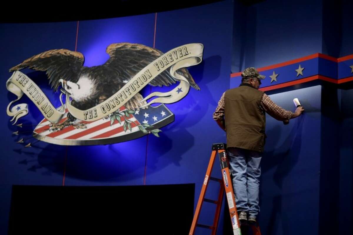 A worker cleans lint off the background of the stage for a debate at the University of Denver Tuesday. President Barack Obama and Republican presidential candidate and former Massachusetts Gov. Mitt Romney will hold their first debate tonight.