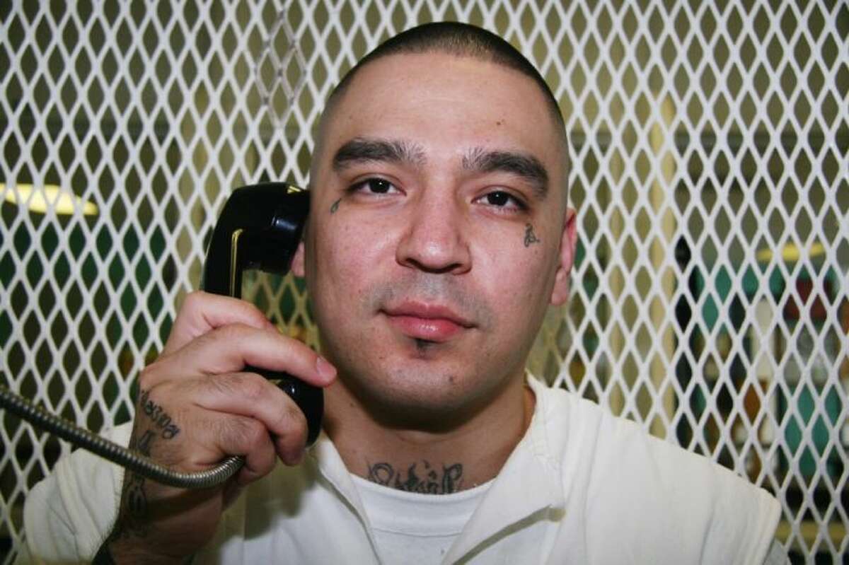 In this July 24 photo, Texas death row inmate Robert Gene Garza speaks on the phone in a visiting cage at the Texas Department of Criminal Justice Polunsky Unit in Livingston.