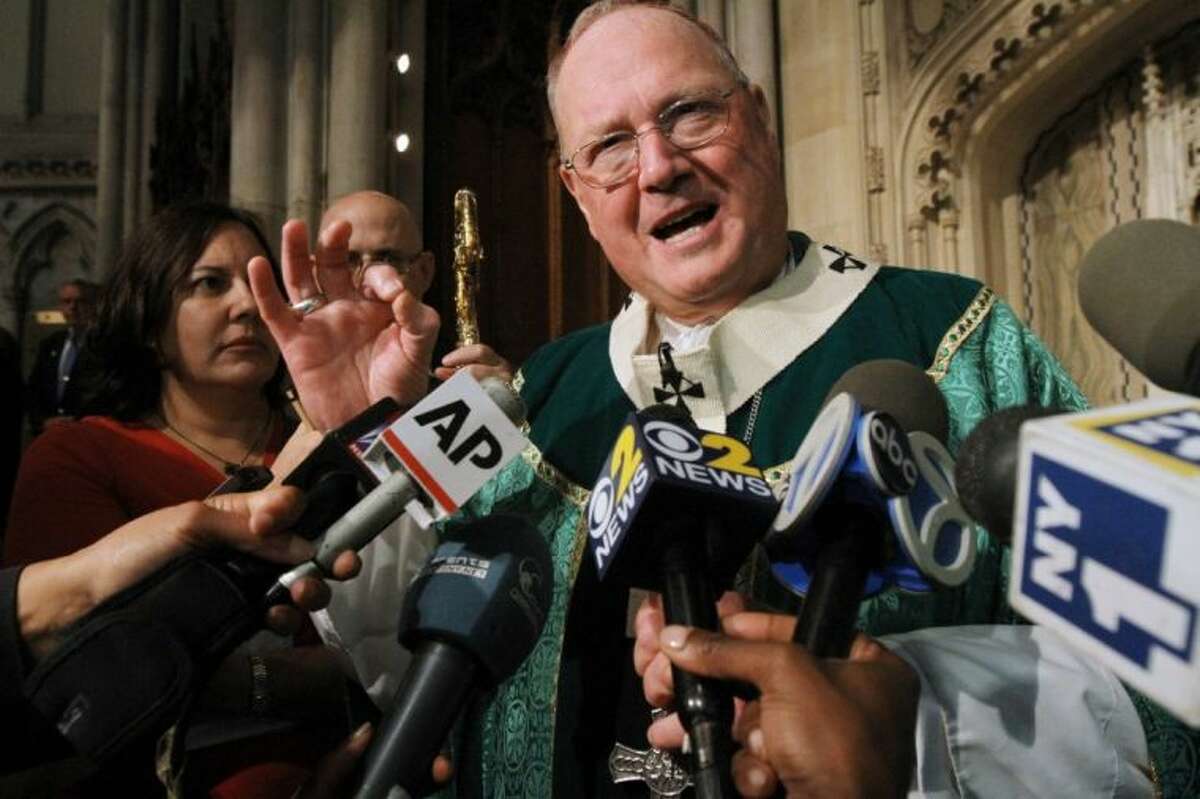Cardinal Timothy Dolan, right, speaks to the media after Mass, Sunday at St. Patrick’s Cathedral in New York.