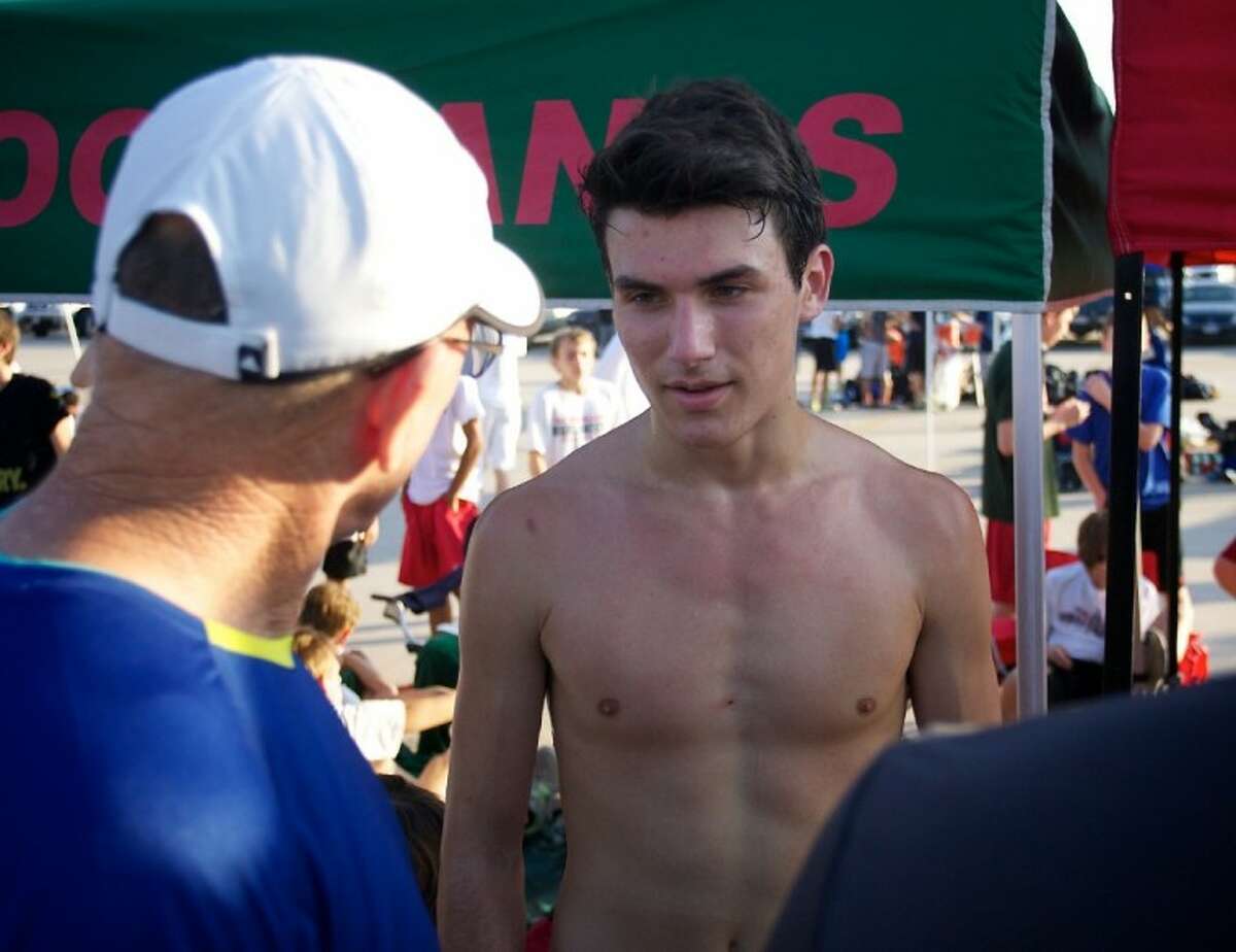 The Woodlands High School senior Brigham Hedges chats with former Highlander coach Dan Green after Hedges finished first in the elite boys varsity race during Saturday’s Nike Cross Country Invitational at the Bear Branch Sports Fields in The Woodlands.