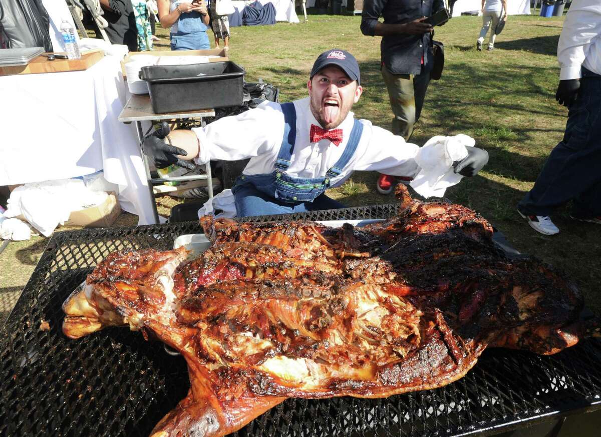 Hoodoo Barbeque Restaurant of Ridgefield grillmaster Mike Peckham busted a move after he and fellow workers finished roasting a 130 pound pig during the Greenwich Wine & Food Festival at Roger Sherman Baldwin Park in Greenwich, Conn., Saturday, Sept. 24, 2016. The annual event benefited Paul Newman's Hole in the Wall Gang Camp, Wholesome Wave and the Greenwich Department of Parks and Recreation, featured a Culinary Village with food and beverage tastings from 90-plus vendors, live music headlined by Ziggy Marley and celebrity chef cooking demonstrations and tastings.