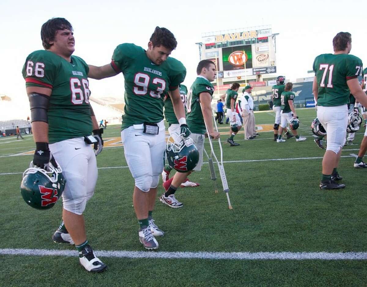 The Woodlands seniors Cody Burkett (66) and Matt Miller console each other after the team’s 34-26 loss to Round Rock Westwood.
