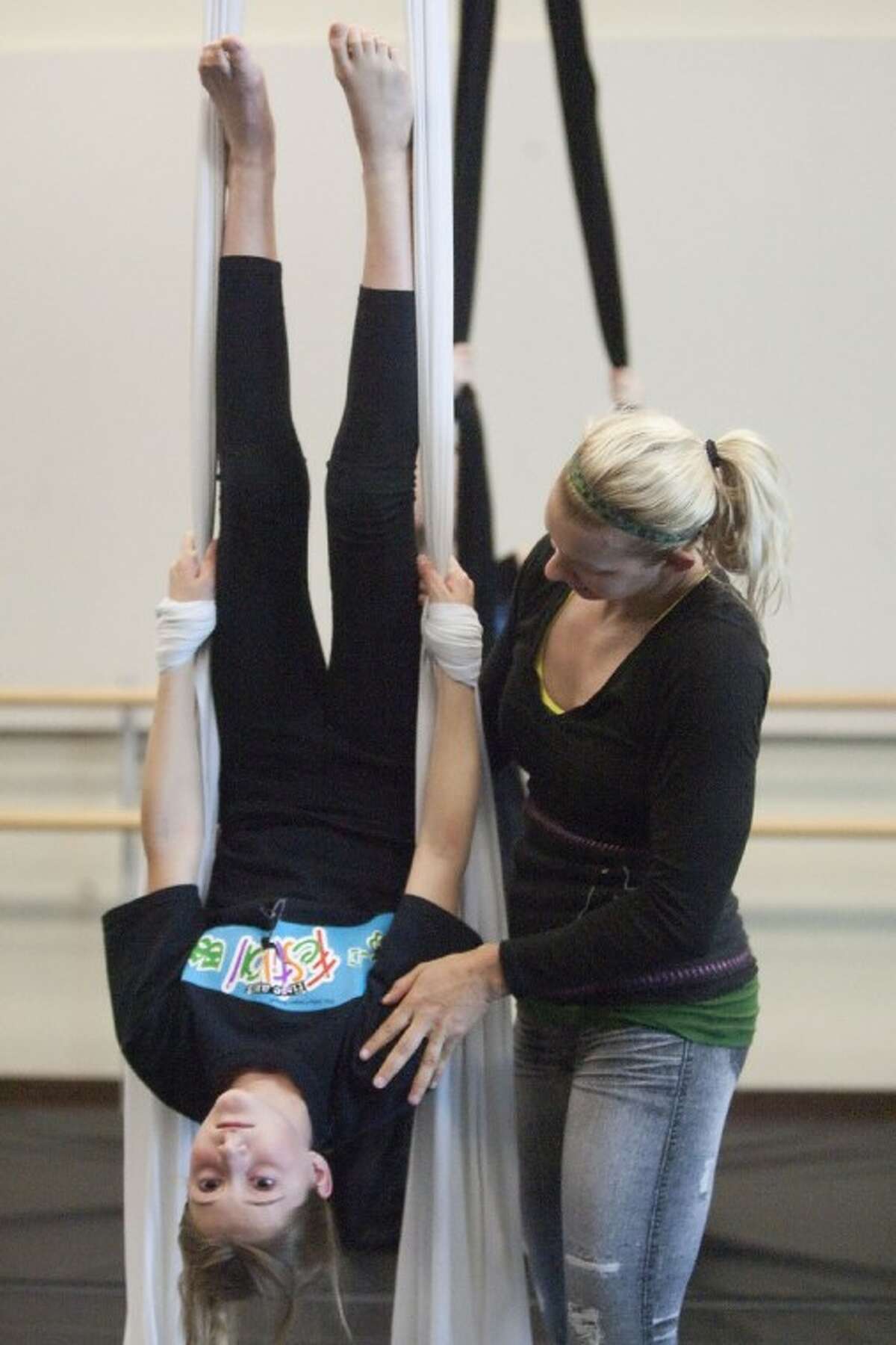 Jill Crook demonstrates silk aerial techniques to Carina Masuelli Friday at the John Cooper School.