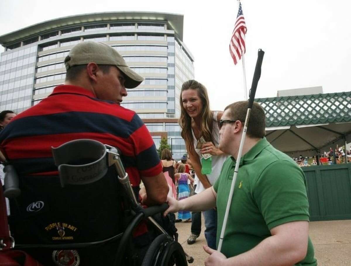 Veterans Marty Gonzalez, left, and Hunter Levine are thanked for their service by a resident as they chat during Memorial Day events at Waterway Square in The Woodlands May 25.