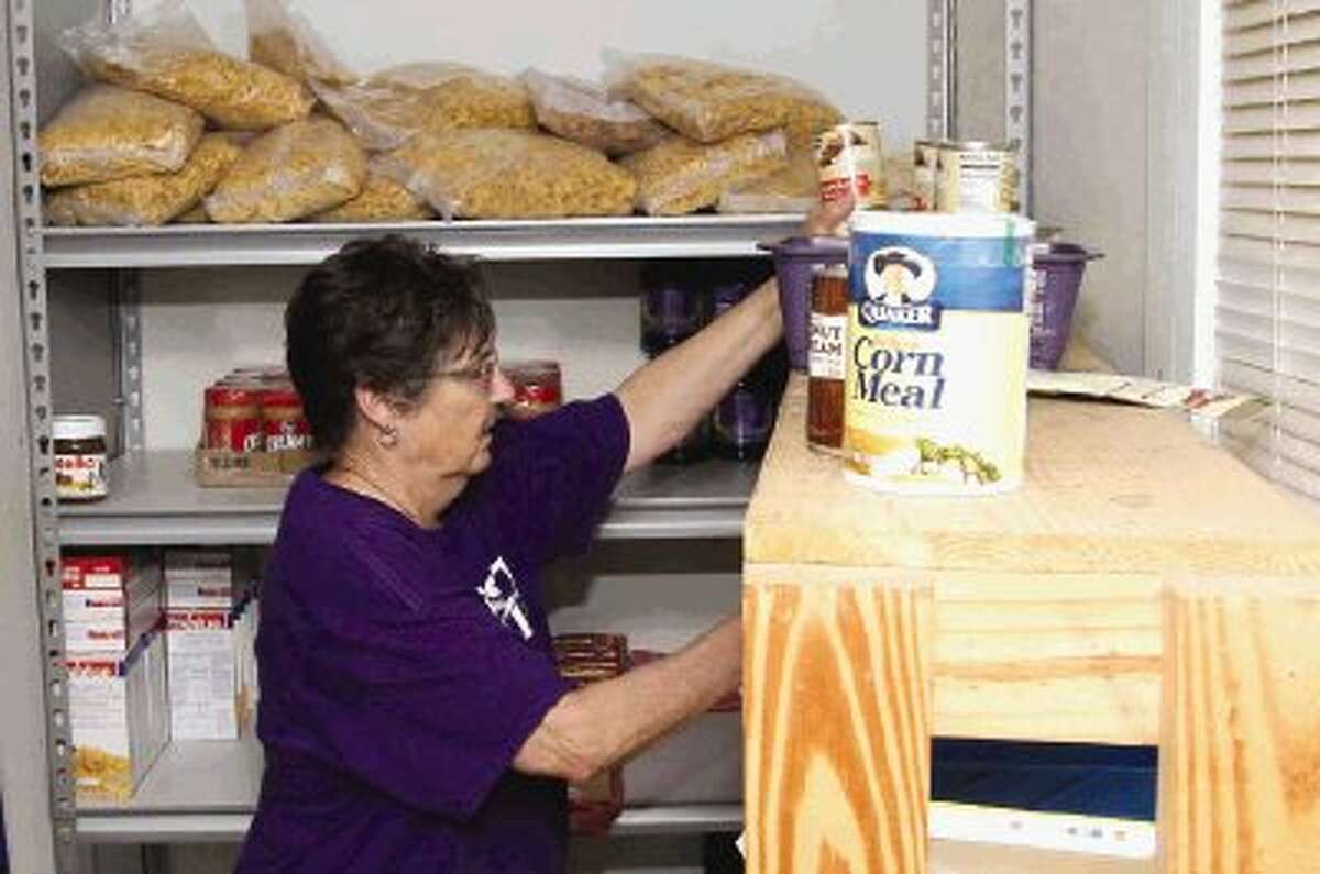 Clara Anderson, a volunteer with the First Baptist Church in Willis, assembles bags of food at the TLC Food Pantry in Willis Thursday. The pantry is asking for donations to help feed out-of-school children who have working parents.