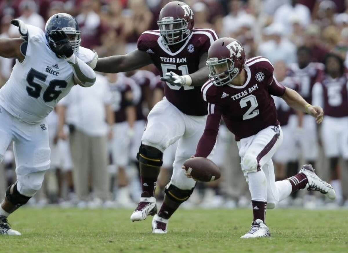 Texas A&M’s Johnny Manziel is pressured by Rice’s Christian Covington. The Aggies whipped Rice 52-31.