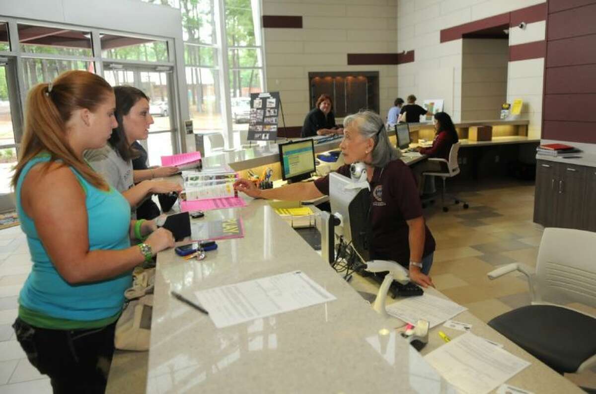 Josie Humphrey, right, helps Ashley Robison, left, of Conroe, and Amber Gutierrez, of Willis, at the front counter of the C.K. Ray Recreation Center in Conroe. The center hosts an open house on Jan. 19.