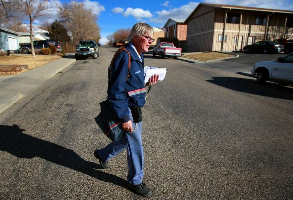 Mail carrier Lou Holscher walks his route Feb. 6 on East 7th Street in Casper, Wyo. Holscher has worked for the Casper Post Office for almost 30 years and said he has seen the volume of mail drop off significantly in recent years.