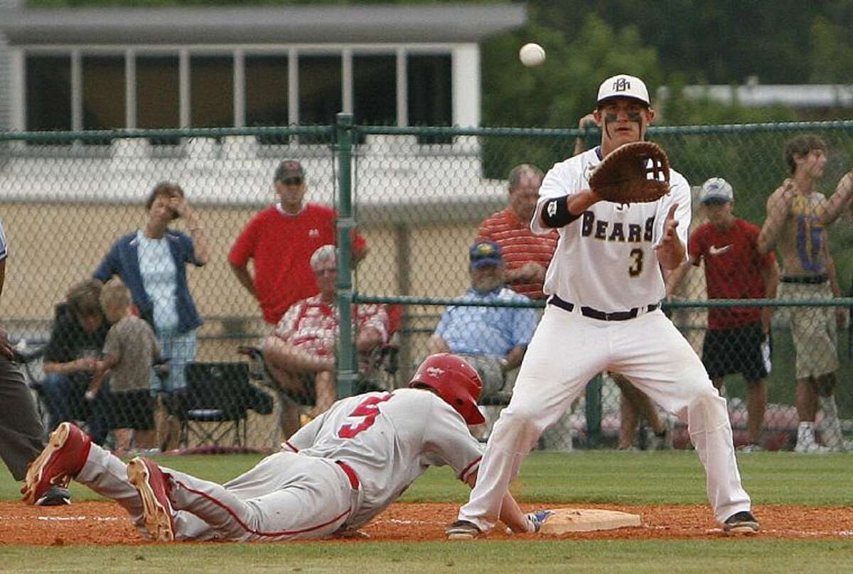 Montgomery first baseman Ty Boland readies for a throw from pitcher Collin Garett as Tomball’s Nick Flacone dives back to first base during Friday night’s Region III-4A playoff game at Montgomery High School. To view or purchase this photo and others like it, visit HCNPics.com.