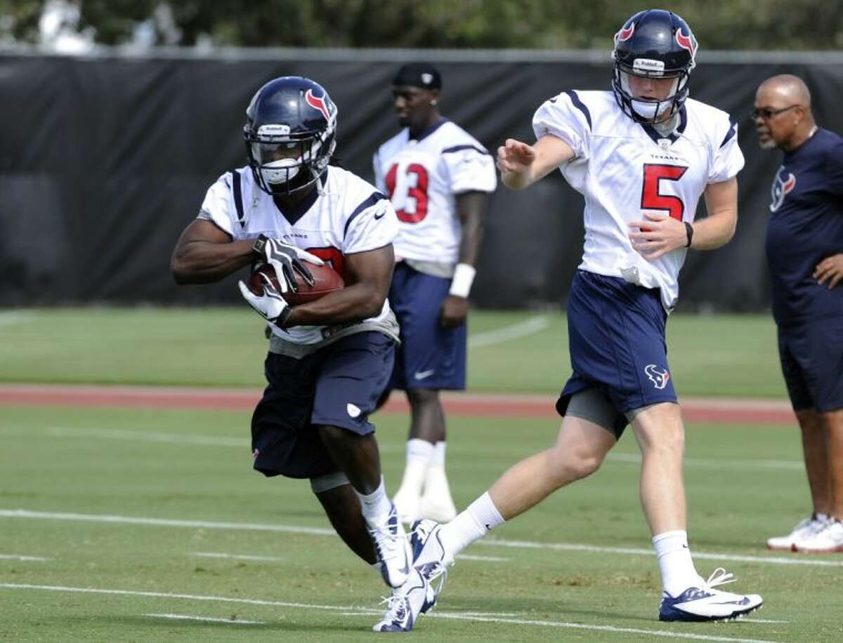 Deji Karim takes a handoff from Houston Texans rookie quarterback Collin Klein during workouts at the Texans’ rookie minicamp Saturday in Houston.