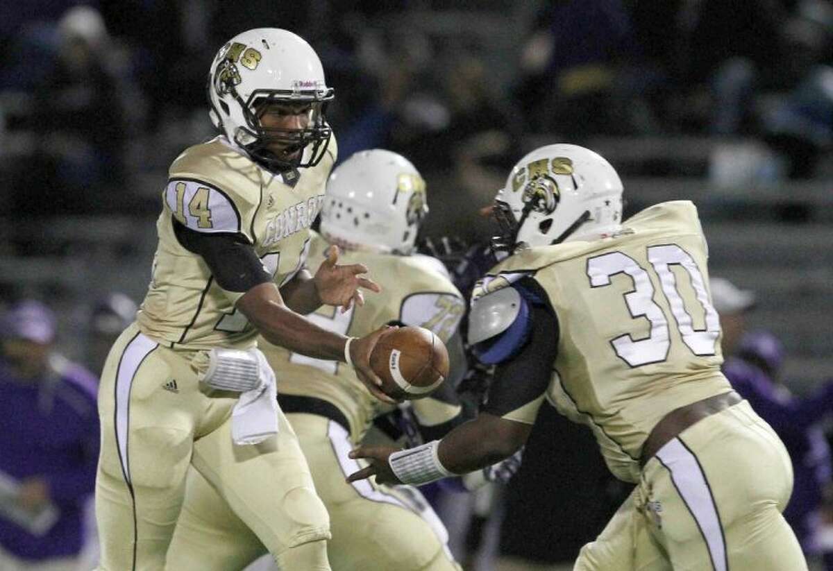 Conroe quarterback Stedman Bell hands the ball to running back Davondric Smith during Friday night’s game against Lufkin. Go to HCNPics.com to view this photos, and others like it.