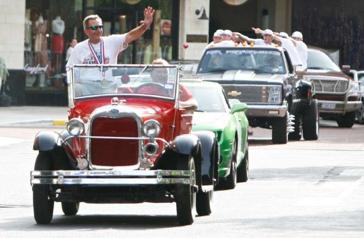 The Woodlands High School baseball coach Ron Eastman waves to residents from atop a classic car as the team entered Market Street in The Woodlands Tuesday. The parade honored the team’s state championship win in Round Rock. To view or order this photo and others like it, visit: HCNPics.com.