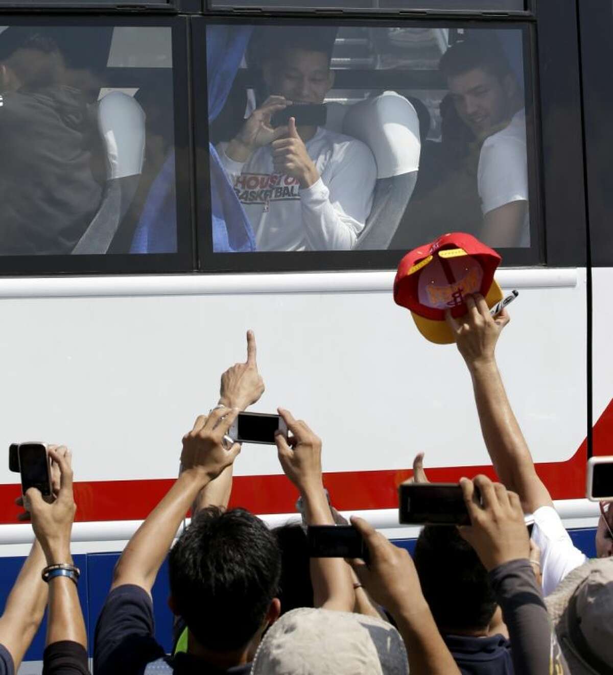 The Houston Rockets’ Jeremy Lin takes photos of Filipino fans upon arrival Monday at the Ninoy Aquino International Airport near Manila, Philippines.