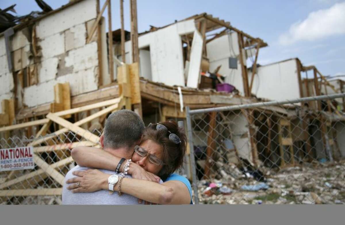Shona Jupe, a resident of the apartment destroyed by the fertilizer plant explosion, hugs her friend as they met while she was visiting the site in West on Friday. Jupe was at the front door when the West Fertilizer Co. explosion happened.