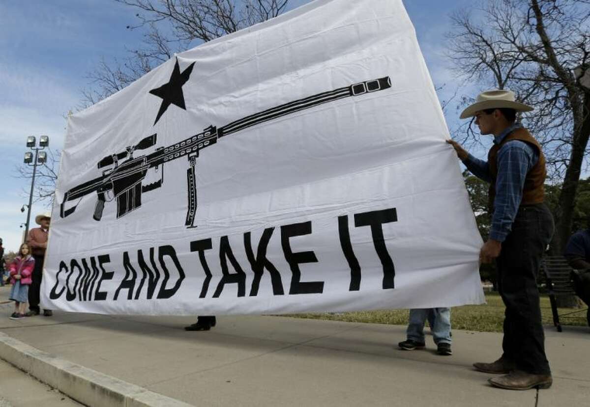 Gun rights supporters hold a large banner at a Guns Across America rally at the Texas state capitol Saturday in Austin. Thousands of gun advocates have gathered peacefully at state capitals across the U.S. to rally against stricter limits on firearms.