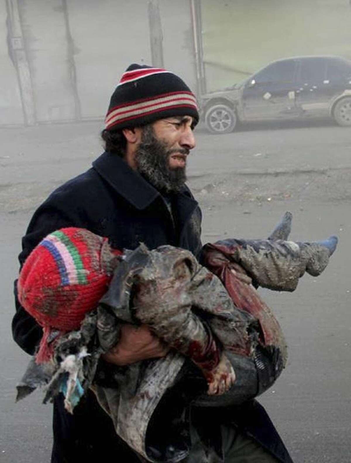 In this Sunday citizen journalism image provided by Aleppo Media Center, AMC, which has been authenticated based on its contents and other AP reporting, a Syrian man cries while holding the body of child who was killed following a Syrian government airstrike in Aleppo, Syria.