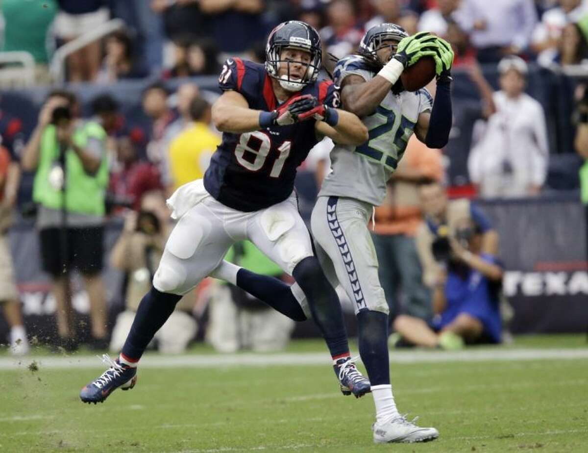 Seattle Seahawks cornerback Richard Sherman intercepts the ball in front of the Houston Texans' Owen Daniels in the fourth quarter. Sherman scored on the play.