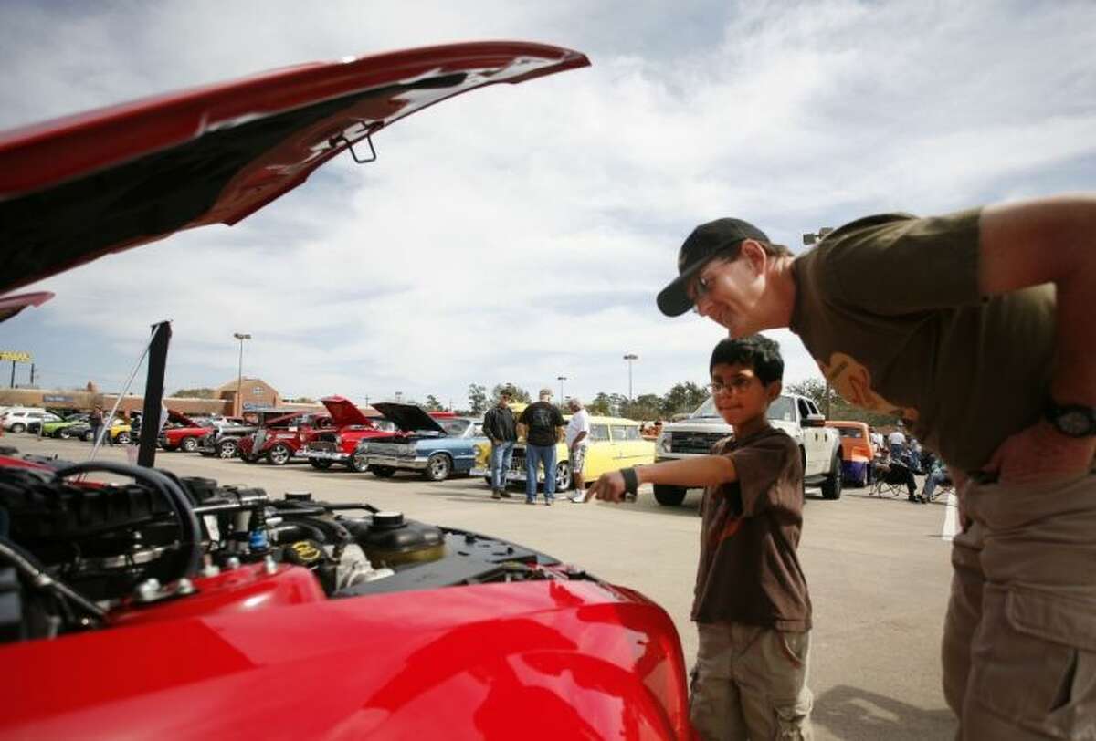 Warren Rumpel and his son Marvin, 9, check out a car display during the Cruise in Against Hunger Food Drive/Car Show on Saturday at The Outlets at Conroe. Rumpel displayed his Stingray Corvette in the show. The event was hosted by the Montgomery County Mustang Car & Truck Club. To view or order this photo and others like it, visit: HCNPics.com