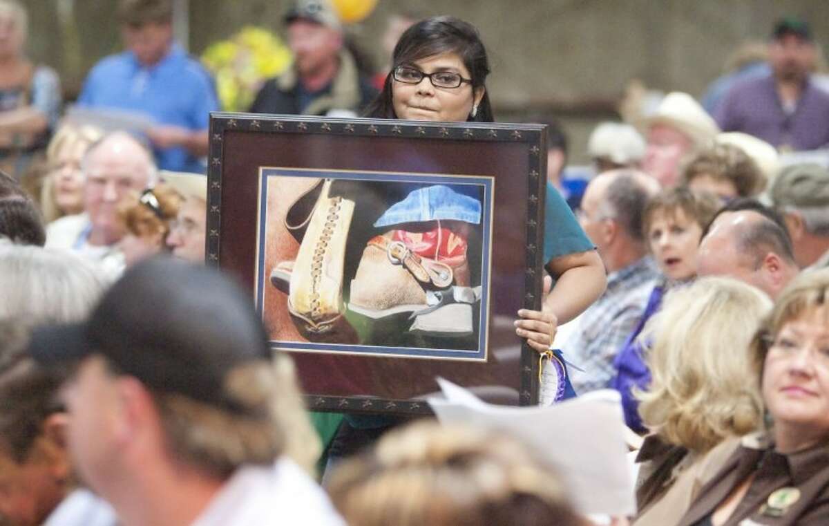 Tabinah Sheikh of Porter High School shows off her photograph during the junior non-livestock auction Monday at the Montgomery County Fairgrounds.