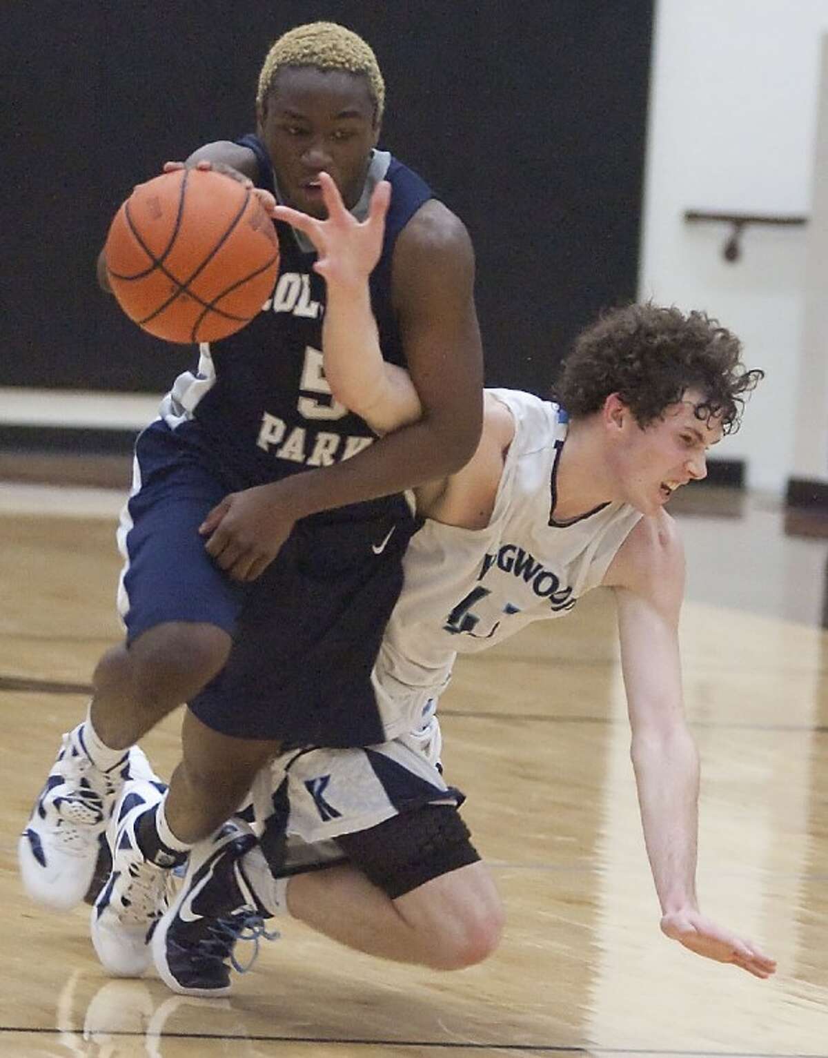 College Park's Desmond Fleming trips over Kingwood's Kyle Phillips Tuesday at Porter High School. See more photos online at www.yourhoustonnews.mycapture.com.
