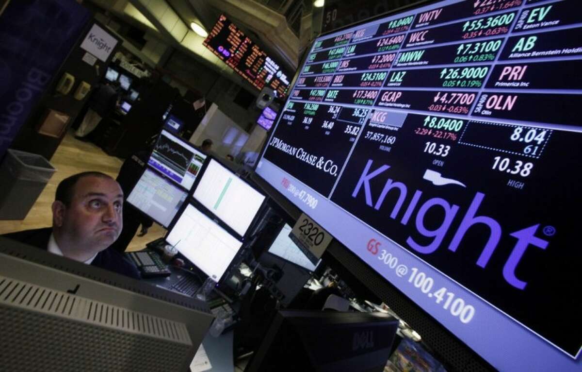 Specialist Peter Giacchi looks at the price of Knight at his post on the floor of the New York Stock Exchange Wednesday. Traders’ attention was diverted to unusually sharp moves in a number of stocks shortly after the opening bell. The New York Stock Exchange says it is reviewing trades in 140 stocks.