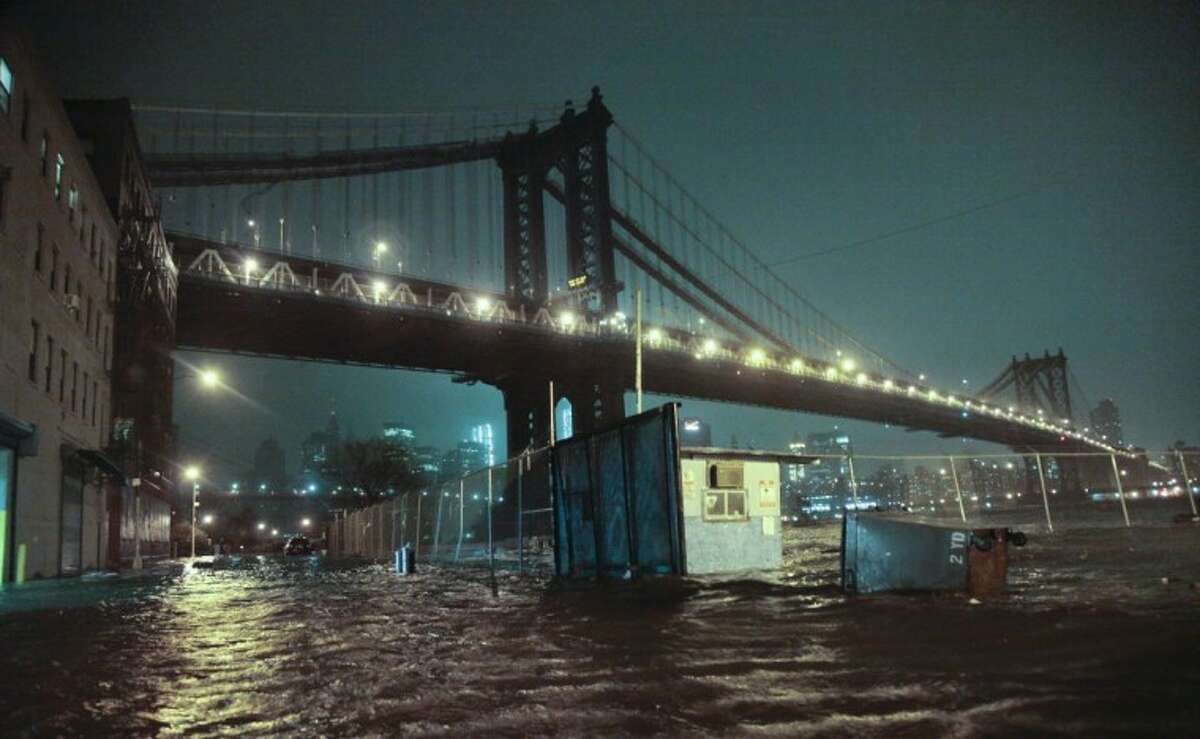 Streets are flooded under the Manhattan Bridge in the Dumbo section of Brooklyn, N.Y., Monday