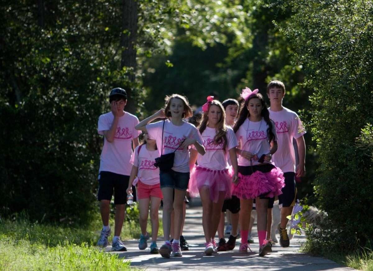 Participants take part in the 5th annual "Paint the Path Pink" event, a 3-mile charity walk at Mitchell Intermediate School benefitting breast cancer research and local victims of the deadly disease on Saturday in The Woodlands.