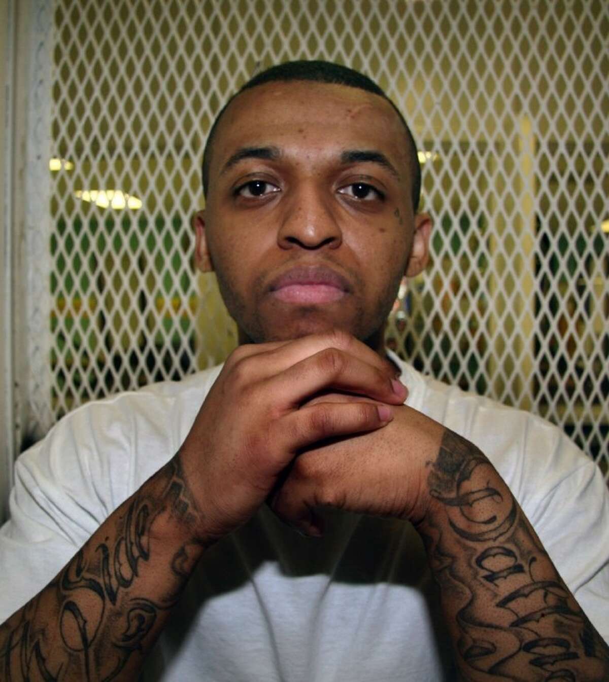 In this Dec. 5, 2012, photo, Texas death row inmate Steven Lawayne Nelson poses for a photo in a visiting cage at the Texas Department of Criminal Justice Polunsky Unit outside Livingston, Texas. Nelson, 25, was convicted of capital murder in mid-October and sent to death row for the 2011 slaying of an Arlington pastor during a robbery.