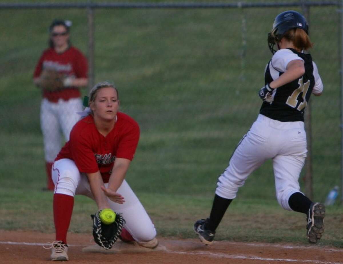 Conroe’s Shelby Davis runs safely to first base as The Woodlands’ Paige McDuffee makes a catch during Tuesday night’s district game in Conroe.