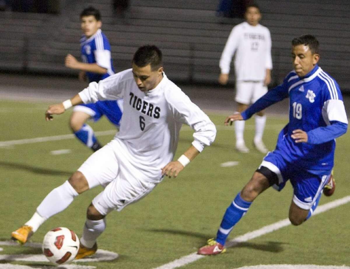 Conroe’s Carlos Santos dribbles past New Caney’s Daniel Garcia during Tuesday night’s game at Moorhead Stadium in Conroe.