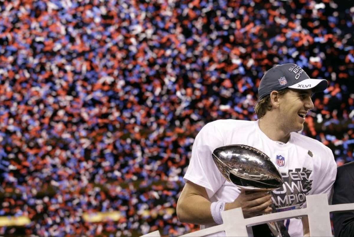 NFL - NFL: Super Bowl XLVI-New York Giants vs New England Patriots Feb 5,  2012; Indianapolis, IN, USA; New York Giants quarterback Eli Manning  celebrates with the Vince Lombardi Trophy after Super