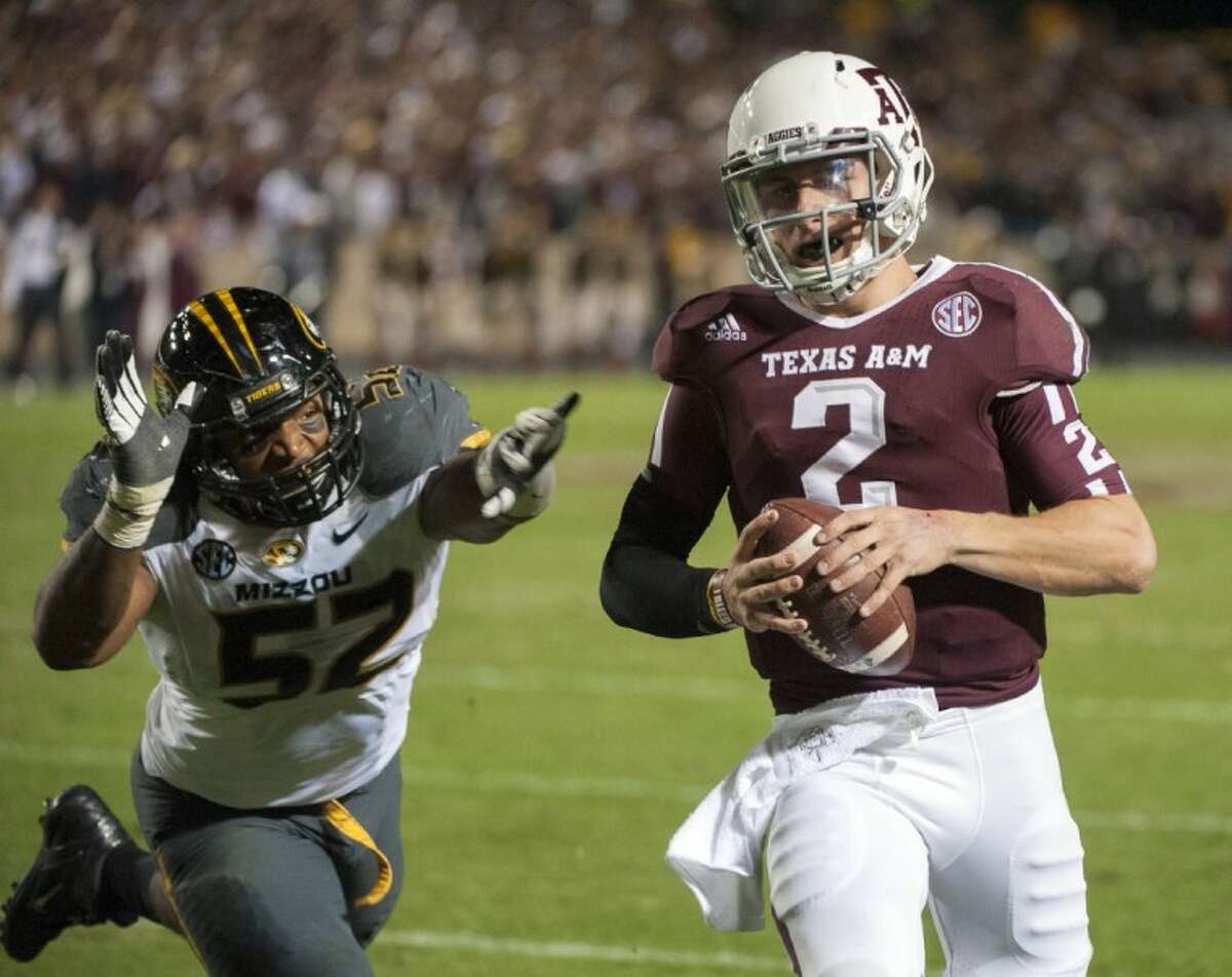 Texas A&M quarterback Johnny Manziel runs from Missouri's Michael Sam on his way to the end zone. The Aggies won 59-29.