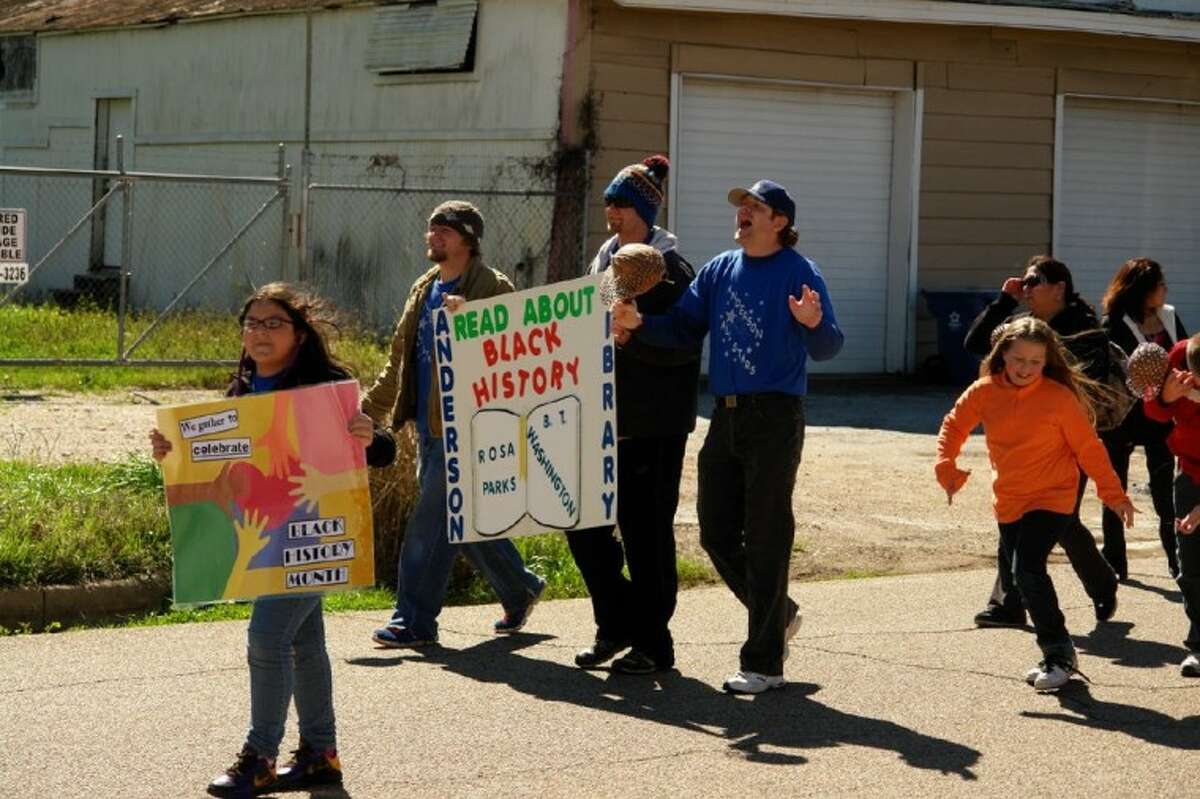 Members and supporters with Anderson Elementary School raise signs in honor of equality and Black History Month education Saturday in the Project Hope Black History Parade in Conroe.