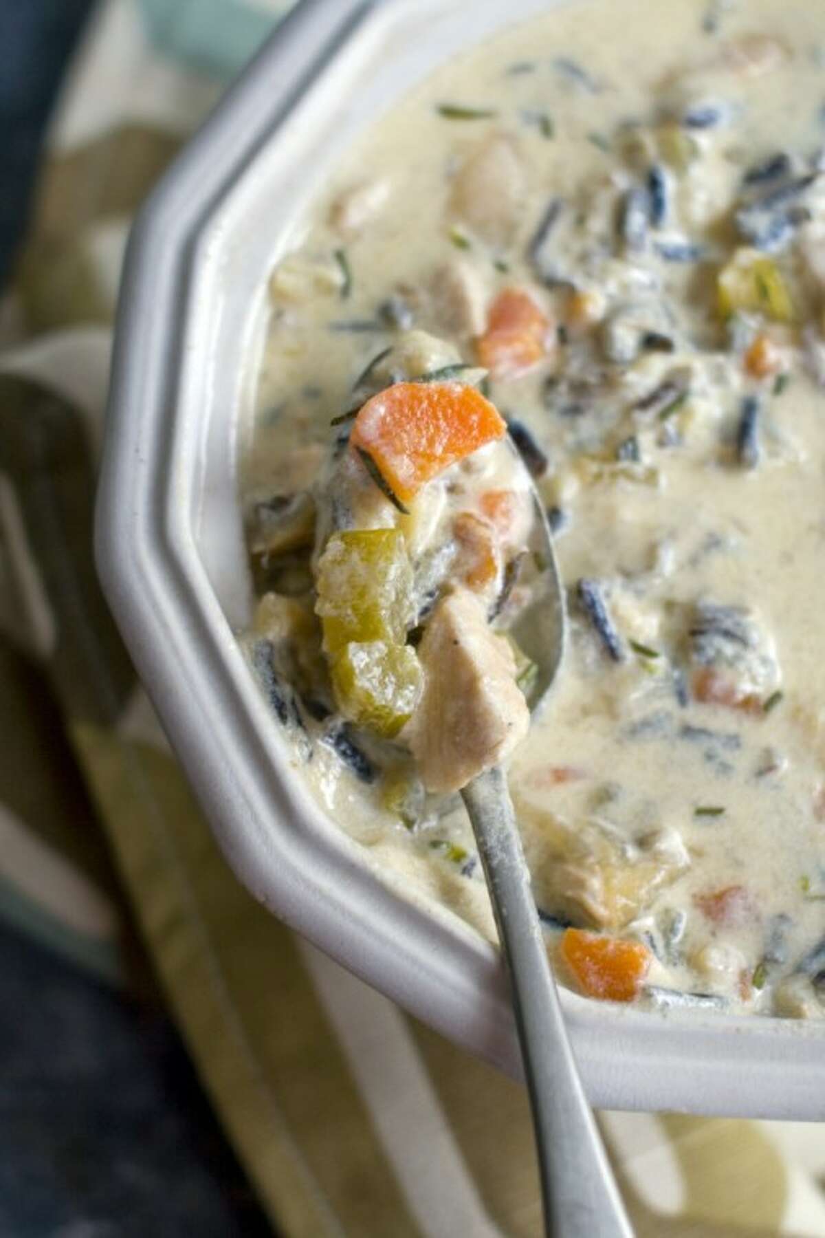 This photo shows creamy rosemary wild rice soup. Creamy in texture without being cream-based, this soup satisfies with vegetables, wild rice and rosemary.