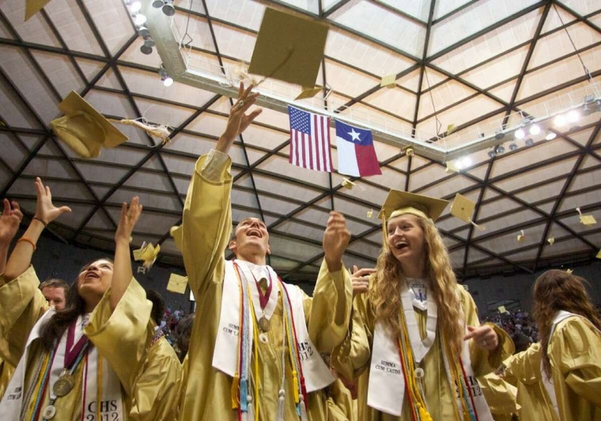 Conroe High School graduates throw their caps in the air in celebration during Saturday’s commencement address at the Johnson Coliseum in Huntsville.