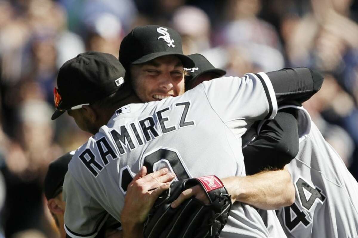 Chicago White Sox starting pitcher Phil Humber, center, is mobbed by teammates after pitching a perfect baseball game against the Seattle Mariners Saturday in Seattle. The White Sox won 4-0.